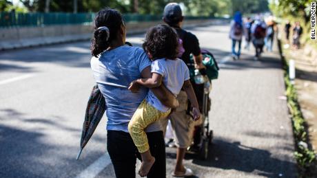 A child is carried as the crowds of migrants walk north from Tapachula.