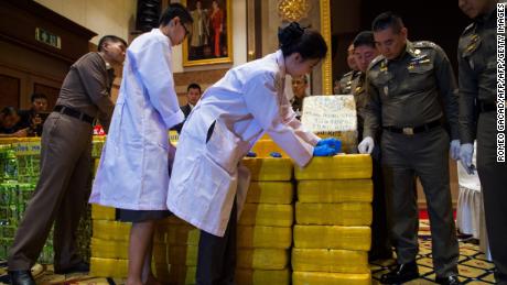 Thai national police chief general Chaktip Chaijinda (second from the right) watches police department chemists inspect seized drugs during a press conference in Bangkok on May 11. Ten million yaba pills made in Myanmar and nearly half a tonne of crystal meth hidden in tea packages was  seized from a convoy in downtown Bangkok, Thai police said. 