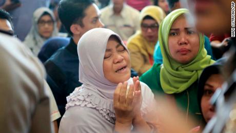 A relative of a passenger prays as she and others wait for news on the Lion Air plane.