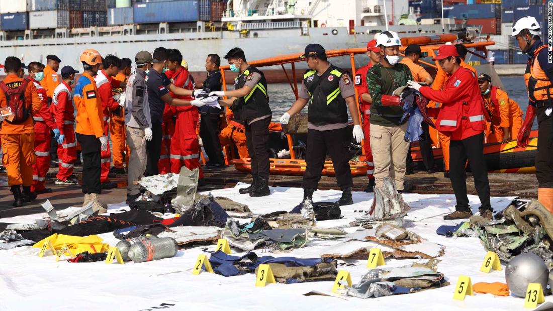 Members of a rescue team bring personal items and wreckage ashore in Jakarta on October 29.