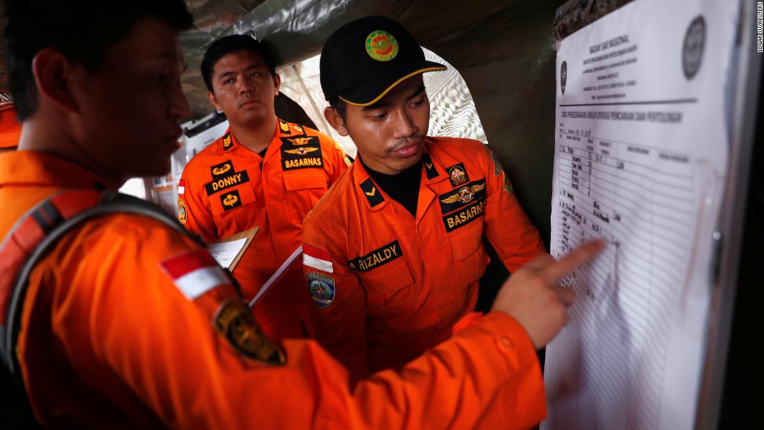 Indonesian rescue team members update a manifest chart on Tuesday, October 30, as they work to retrieve the bodies of those who died in the Lion Air flight JT610 crash.