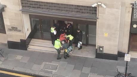 A person is carried out of a building on a stretcher in Derry Street, Kensington, on Friday.