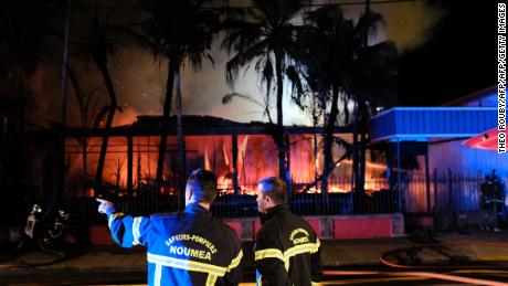 Firefighters try to extinguish a house set on fire in downtown Noumea overnight on November 5, 2018, after the results from an independence referendum in the French Pacific territory of New Caledonia.