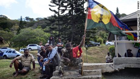 An activist holds the pro-independant flag during a meeting of the Kanak and Socialist National Liberation Front (FLNKS) campaign for a &#39;yes&#39; to New Caledonia&#39;s independence from France in Noumea.