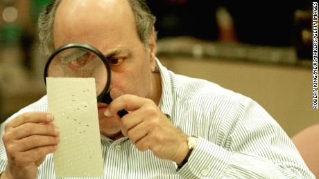 Judge Robert Rosenberg uses a magnifying glass to examine a punch card ballot on November 24, 2000 during a vote recount in Fort Lauderdale, Florida.  The close 2000 race led to a recount in some counties in Florida. 
