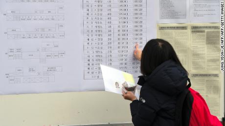 Un élève vérifie le numéro de sa salle d'examen avant le test annuel des aptitudes au collège, un examen standardisé pour l'entrée au collège, dans une école secondaire de Séoul le 23 novembre 2017.