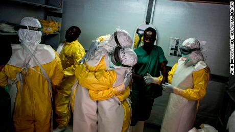 Gesundheitspersonal umarmt sich, bevor es 2018 in die rote Zone eines Ebola-Behandlungszentrums in Bunia, Demokratische Republik Kongo, geht.