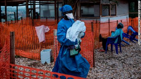     A health worker carries a four-day-old baby suspected of having Ebola virus in Butembo town.