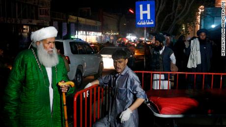 Afghan religious scholars wait outside the emergency hospital after a suicide bomber targeted a religious gathering at a wedding hall in Kabul.