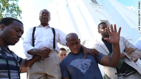 A pastor leads a group in emotional prayer after masscare within a Charleston church.