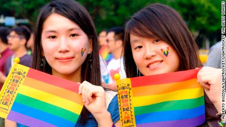 Two young women sport rainbow flags in favor of same-sex marriage at a gay pride parade in Taipei in October 2018.