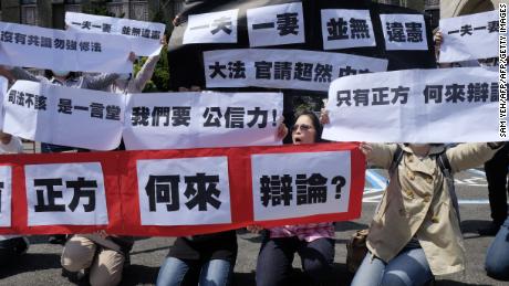 Conservative activists display signs reading &quot;one husband, one wife does not go against the constitution&quot; in Taipei, on March 24, 2017.