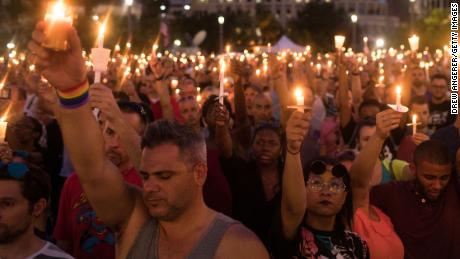Hundreds of people hold candles at a memorial after the Pulse Nightclub shooting in Orlando, Fla.
