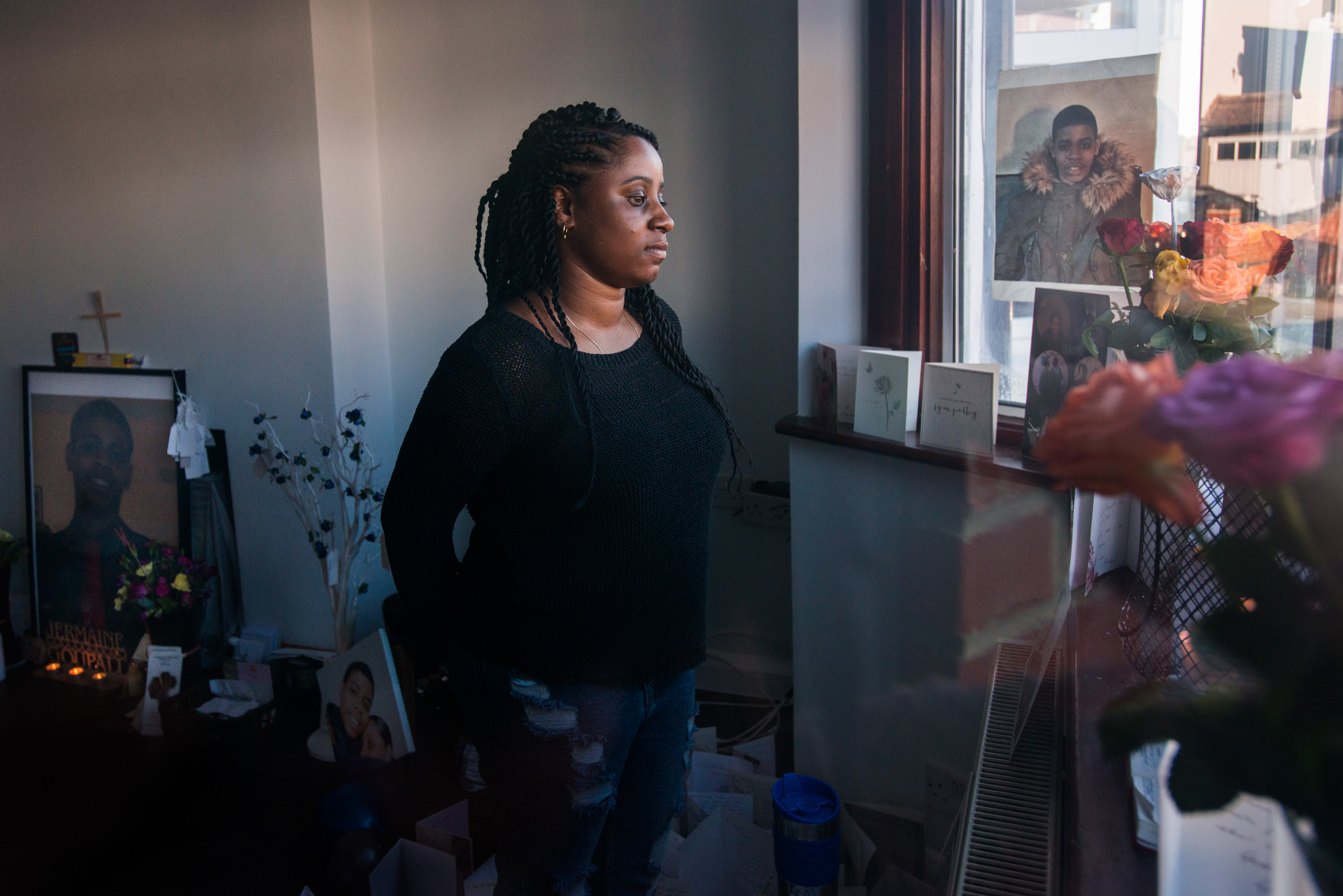 Goupall is seen through the window of her family&#39;s front room in Thornton Heath, south London. The room has become a shrine dedicated to honoring the life of her brother, Jermaine.
