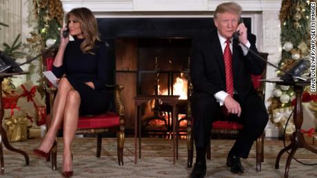   President Donald Trump and First Lady Melania Trump respond to calls from people entering NORAD's Santa Claus tracking line at the White House on December 24, 2018. 