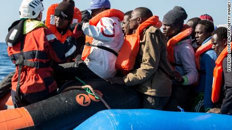 A group of 47 migrants is helped by a Sea Watch 3 crew member (left) during a rescue operation off Libya in January 2019. 