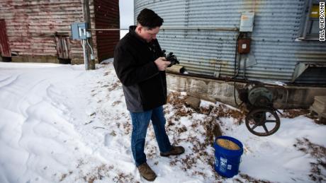   Brian Wolken, farmer and mayor of Monticello, checks soy subsidies on his phone. 