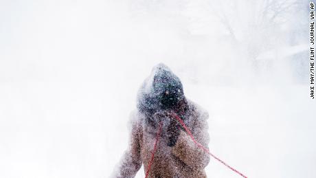   Sarah Allen clears her driveway and sidewalks with a snowblower in Flint, Michigan. 