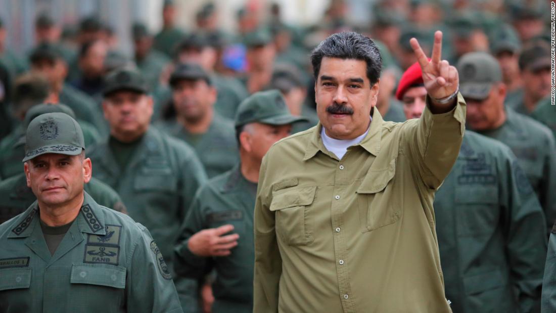 In this handout photo released by the Miraflores Presidential Press Office, Maduro flashes a &quot;V for victory&quot; hand gesture after arriving at the Fort Tiuna military base in Caracas on January 30.
