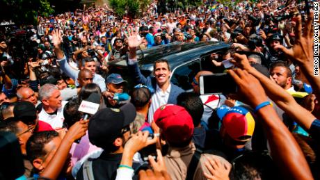 Juan Guaido waves to supporters as he leaves a Saturday rally in Caracas.