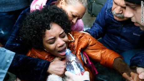 Yandy Smith is helped by others after she was sprayed with pepper spray after she and others stormed the main entrance to the Metropolitan Detention Center on Sunday.