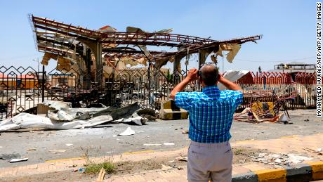 A Yemeni man takes a picture of a destroyed petrol station that was hit by an airstrike in Yemen&#39;s capital Sanaa on May 27, 2018.
