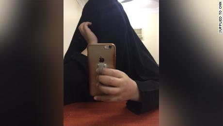 The younger sister takes a selfie in a hotel room. They say they felt like &quot;ghosts&quot; under the full-length black robe, as if they were invisible, not there. 