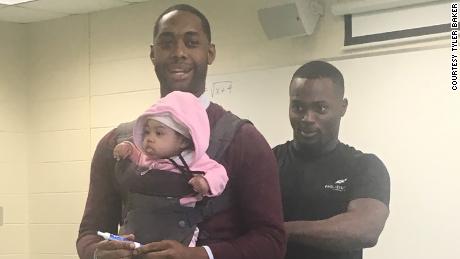 A student could not find a babysitter. So, his teacher held his little girl in class so that he could take notes