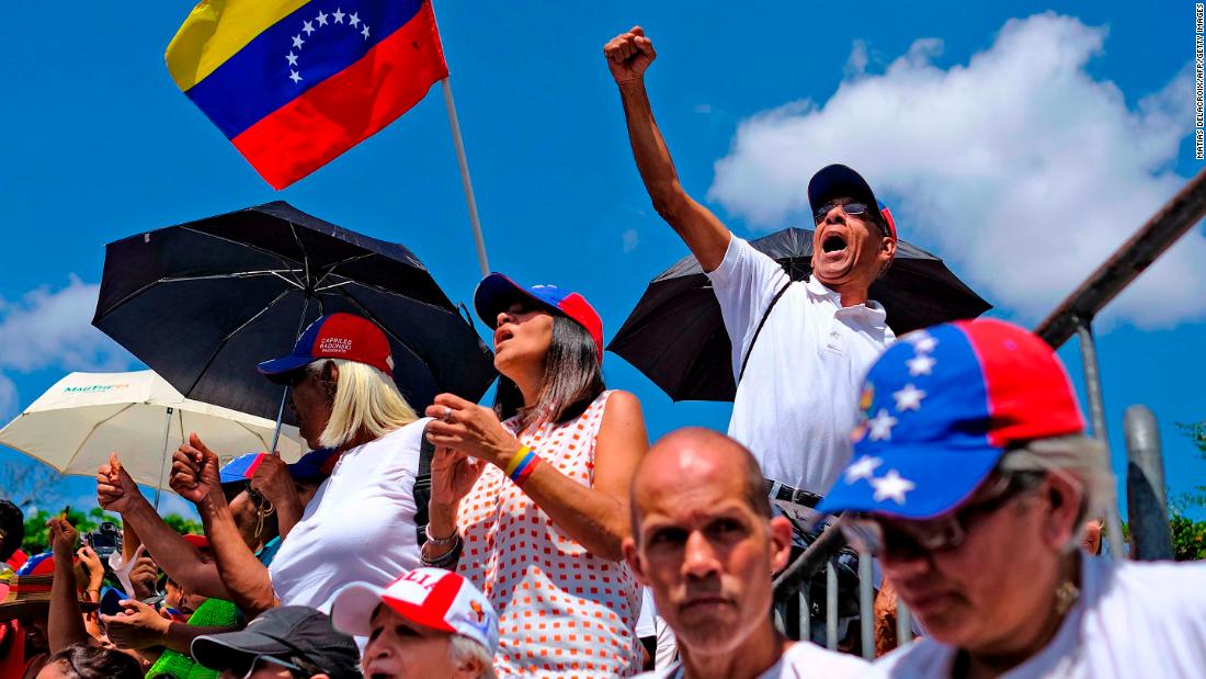 Supporters of Venezuelan opposition leader Juan Guaido wave a Venezuelan flag as they wait for him to make an appearance in the country&#39;s capital of Caracas on Monday, marzo 4.
