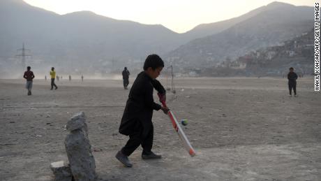 An Afghan boy bats in front of a makeshift set of stumps at an esplanade at Shuhada Lake in Kabul -- a city now obsessed by the sport.