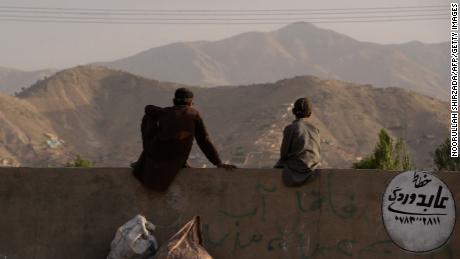 A pair of young Afghans sit on a wall as they watch a game on the outskirts of Kabul. &quot;When I started filming them, they didn&#39;t have a grass pitch in the whole country. A lot of the guys had never played with a leather ball,&quot; Albone reflects.