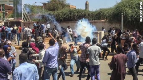 Sudanese protesters run for cover from tear gas canisters fired by security forces on Saturday.