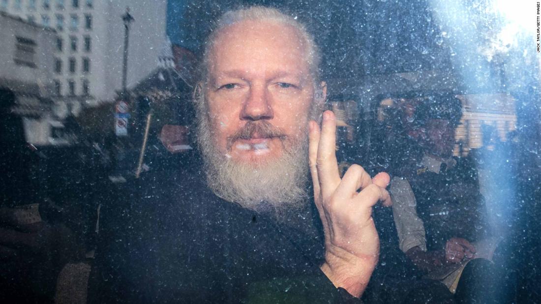 Julian Assange gestures from a police vehicle after arriving at the Westminster Magistrates&#39; Court in London in April 2019.