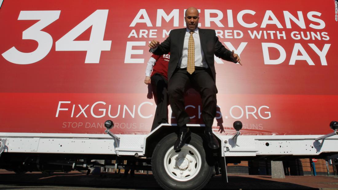 Booker leaps from the wheel cover of a mobile billboard after taking photos on it in February 2011. The truck was driven across the nation to draw attention to US gun laws. 