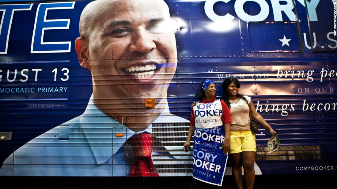 Women pose next to Booker&#39;s campaign bus during a rally in Newark in August 2013. Booker was running for the US Senate seat that was vacated when five-term incumbent Frank Lautenberg died at the age of 89.