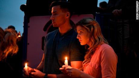 Participants hold candles during a vigil Sunday evening.