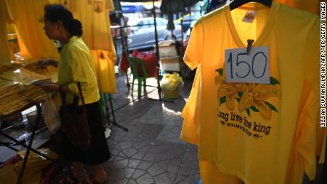 A woman browses through yellow shirts in honor of Thailand&#39;s King Maha Vajiralongkorn being sold in Bangkok on April 25, 2019, ahead of his royal coronation. 