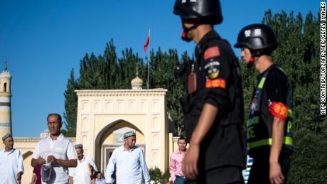 Police patrol as Muslims leave the Id Kah Mosque after morning prayers in the old town of Kashgar in China&#39;s Xinjiang Uighur Autonomous Region. 
