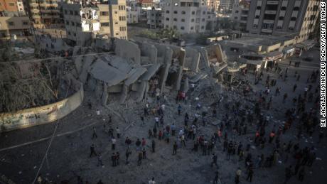 Palestinians inspect the remnants of the Abo Kamar building after airstrikes carried out by Israeli warplanes in Gaza City, Gaza, on Sunday