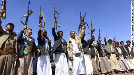 Armed men raise their weapons as they gather near Sanaa to show their support of the Houthi movement in February.