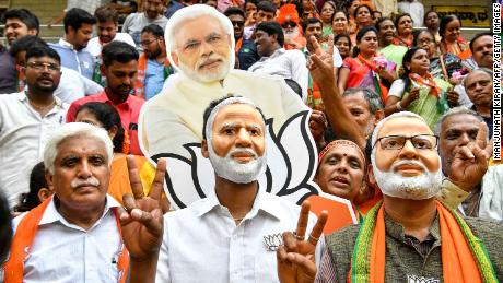 Supporters wear masks of Indian Prime Minister Narendra Modi and flash victory signs as they celebrate on the vote results day for India&#39;s general election on May 23, 2019. 