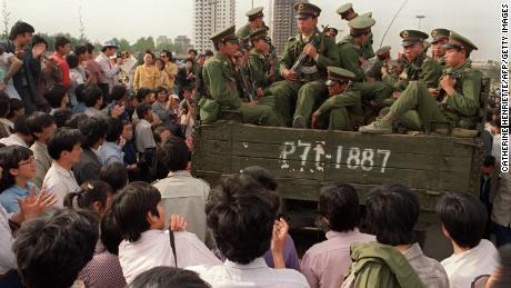 Pro-democracy demonstrators surround a truck filled of People&#39;s Liberation Army (PLO) soldiers on 20 May 1989 in Beijing on their way to Tiananmen Square.