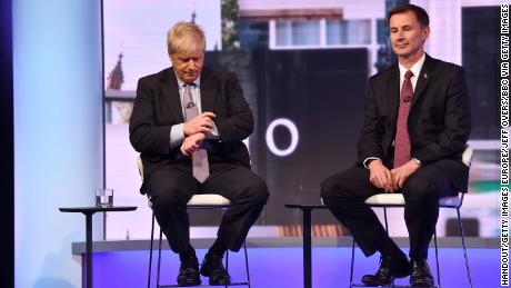 Boris Johnson, sitting next to UK Foreign Secretary Jeremy Hunt, checks his watch during the Conservative Leadership debate on June 18.
