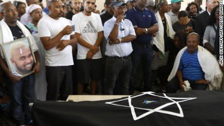 The father of Solomon Teka mourns over his body during his funeral in Haifa on Tuesday.