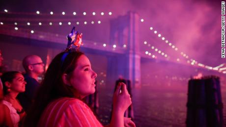 People watch fireworks light up the Brooklyn Bridge during the annual Macy&#39;s fireworks show on the East River from Manhattan July 4, 2019.