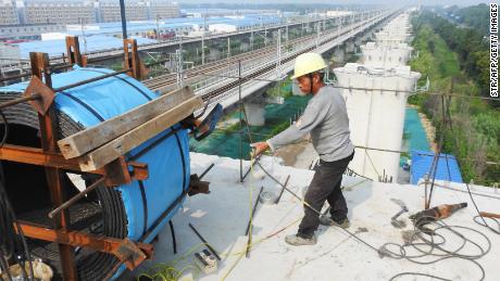 A worker stands on the pillar of a bridge under construction for China's high-speed rail network in Lianyungang, Jiangsu Province.