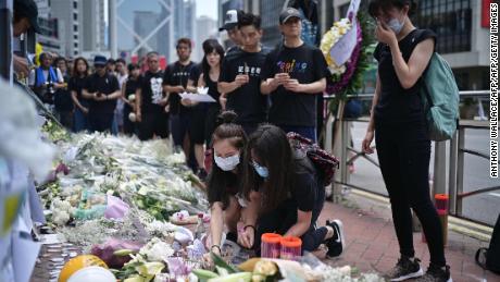 Mourners in Hong Kong place flowers and offer prayers on June 16, 2019, at the site where a protester died.