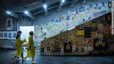 People walk in front of a so-called &quot;Lennon Wall&quot; where messages of support have been left for anti-extradition bill protesters on July 1, 2019 in Hong Kong.