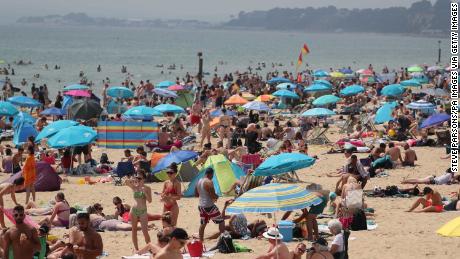 People enjoy the hot weather at a beach in Bournemouth, UK.