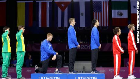 2 American athletes kneel and raise a fist to protest